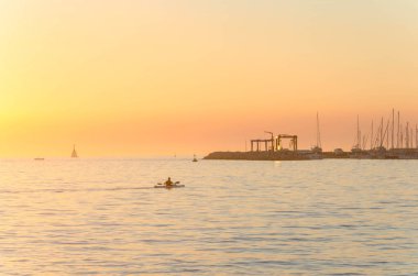 Hırvatistan 'ın Umag limanında gün batımında kanoya binmek