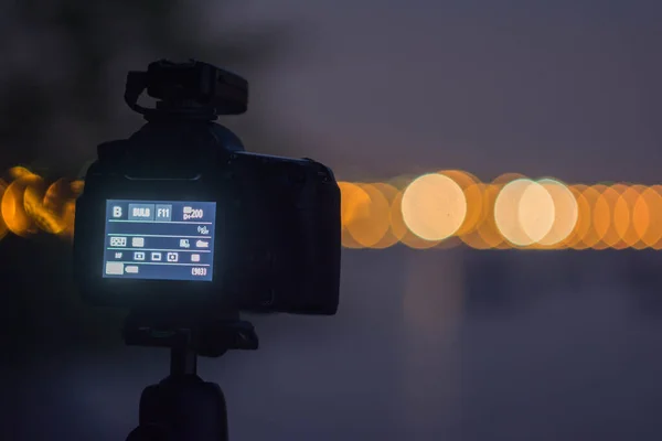 Camera on a tripod shooting a city at night. Shot at Lago di Garda in Italy.