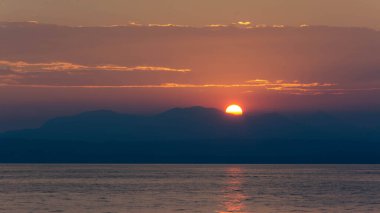 Güneş İtalya 'daki Garda Gölü' nde büyük bir dağın ardında batıyor..