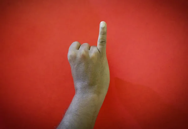 Human showing one finger count signs isolated on red background