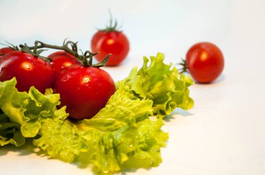 Beyaz arka planda domatesler kırmızı ve yeşil marul