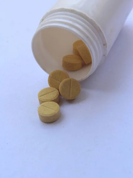 Beyaz arka planda sarı ilaç