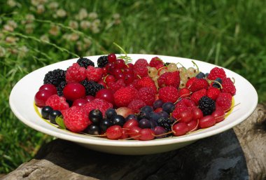 Bir tabak taze kokulu bahçe meyvesi var..
