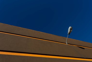 Parlak sarı çizgiler parlak mavi gökyüzüne karşı sönük bir sokak lambası, Braga, Portekiz.