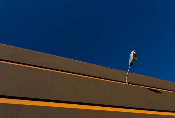 Glowing Yellow Lines against a vibrant blue Sky with a turned off street lamp, Braga, Portugal.