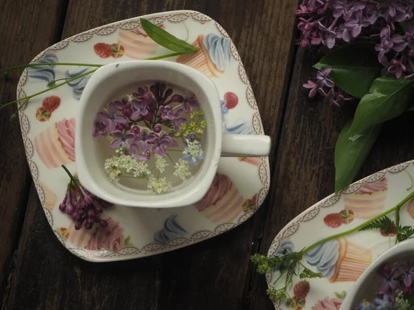 Masanın üzerinde leylak yaprakları olan Fransız fincanı Fransız tarzı.