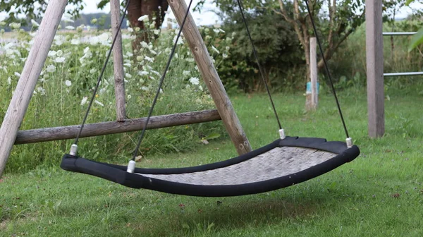 Old lonely swing in the garden. The children have grown, the swings have remained.