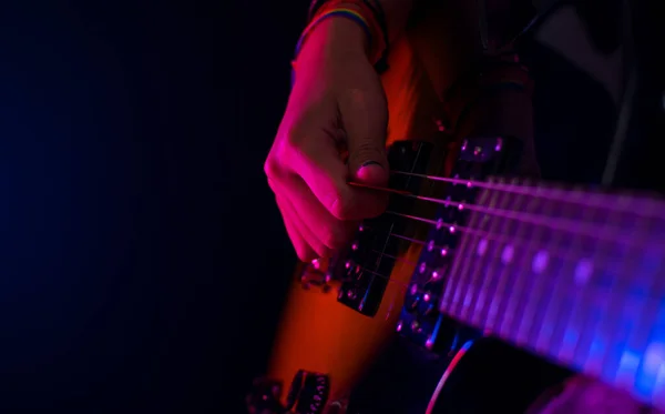 Konser ışıkları ve siyah arka planda gitar çalan kız