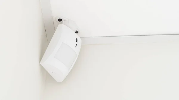 Modern white motion sensor on the wall in the room