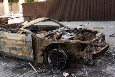İntikam için kundakçılık. Sokağa park edilmiş yanmış bir araba, yakın plan.