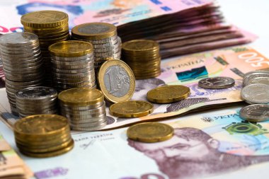 Çeşitli metal paraların, Ukrayna banknotlarının ve euro banknotlarının renkli soyut arkaplanı. Para ve finans, başarılı yatırım kavramı.