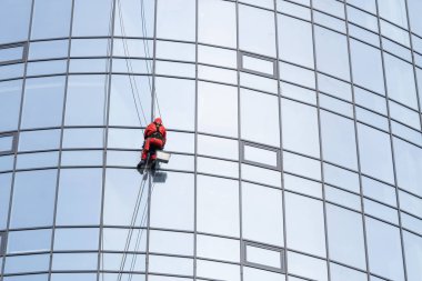 Modern bir binanın pencerelerini temizleyen bir işçinin portresi