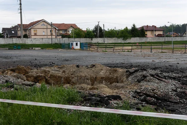 A hole in the ground from a cannon explosion of a Russian shell in the Kyiv region in Ukraine 2022. A crater from shelling in a vegetable garden in a Ukrainian village.