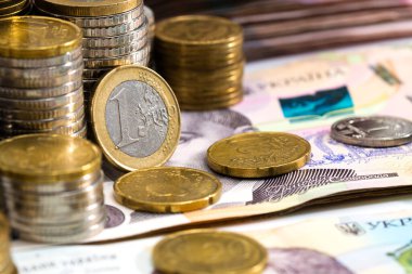 Çeşitli metal paraların, Ukrayna banknotlarının ve euro banknotlarının renkli soyut arkaplanı. Para ve finans, başarılı yatırım kavramı.