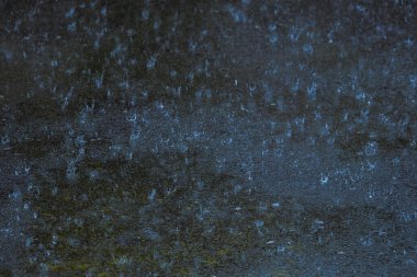 Şiddetli yağmur gününde yağmur damlası yere düşüyor.