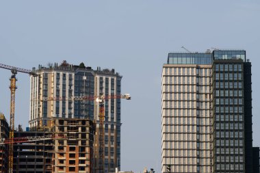 İnşaat alanı. Yüksek katlı çok katlı binalar inşa ediliyor. Binanın yakınındaki kule vinçleri. Sanayi geçmişi.