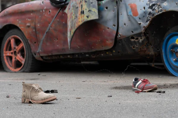 KYIV REGION, UKRAINE 05.04.2022 Irpin, Bucha, Dmitrivka. Atrocities of russian army in the suburbs Kyiv. Childrens shoes from civilian car, fired upon, burned by russian soldiers. War russia Ukraine.