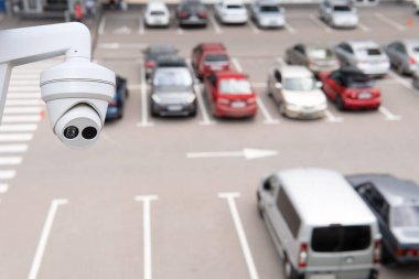 Technician installed IP CCTV camera hi-technology for look security area of work in car parking lot show signage with security cars park in area.