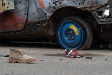 KYIV REGION, UKRAINE 05.04.2022 Irpin, Bucha, Dmitrivka. Atrocities of russian army in the suburbs Kyiv. Children's shoes from civilian car, fired upon, burned by russian soldiers. War russia Ukraine.