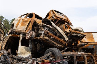 war in Ukraine. Car graveyard. Cars of civilians were shot. Russia's war against Ukraine. Burnt and blown up car. Cars damaged after shelling. irpin bucha. war crimes.