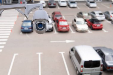 Technician installed IP CCTV camera hi-technology for look security area of work in car parking lot show signage with security cars park in area.