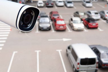 Technician installed IP CCTV camera hi-technology for look security area of work in car parking lot show signage with security cars park in area.