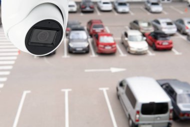 Technician installed IP CCTV camera hi-technology for look security area of work in car parking lot show signage with security cars park in area.