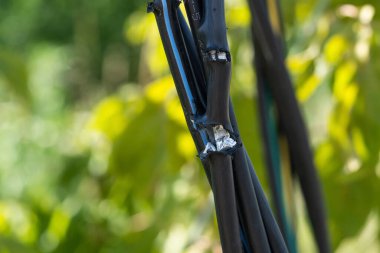 Siyah zemin elektrik kablosu kopmuş. Elektrik sızıntısına ve şoka neden olabilecek tehlikeli bir elektrik kablosu. Güvenli olmayan iş kavramı