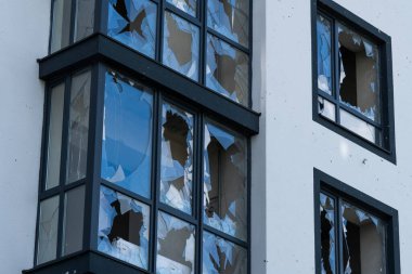 Kırık cam kırıkları. Kırık çerçeveli cam plastiği yıkılmış. Binanın bombalanması, cam kırılması, bina sigortası, ev patlaması, gaz patlaması.