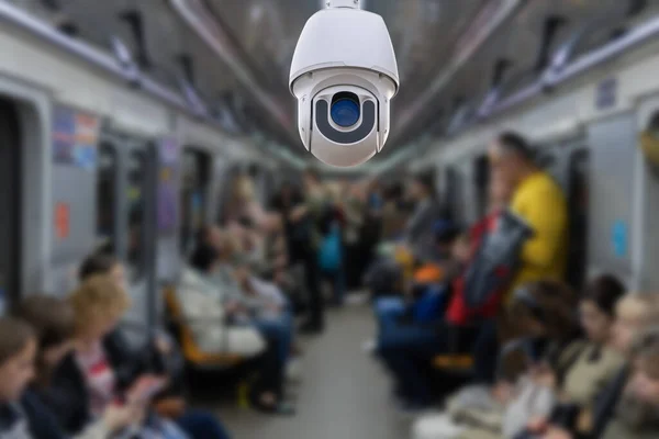 Security camera monitoring attach on ceiling inside subway metro train to surveillance safety of passenger in rush hour and can watch all time, blur people background