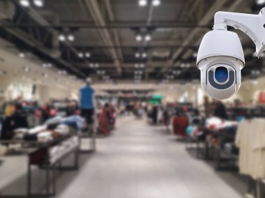 Arka planda güvenlik kamerası mağazası var..