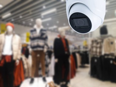 Arka planda güvenlik kamerası mağazası var..