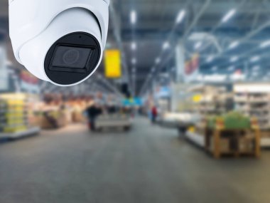 Arka planda güvenlik kamerası mağazası var..