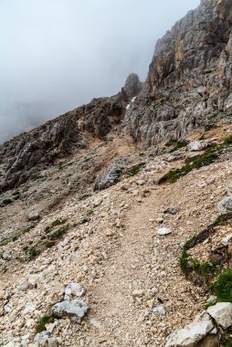 İtalya 'nın Dolomites dağlarında Passo delle Coronelle yakınlarında yürüyüş yapmak bulutlu yaz gününde