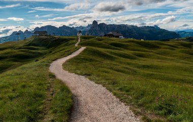 Pralongia ile kaplı, patikalı çayır, kaldırma istasyonu ve kulübe ve İtalya 'daki Dolomiti dağlarında Corvara' nın üzerinde yüksek kayalık tepeler