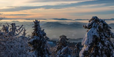 Slovakya 'daki Kysucke Beskydy Dağları' nda kışın Velka Raca tepesinden dağ sırtları ve vadilerdeki sisli yürüyüş parkurlarına bakın.