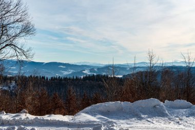 Morevaskosske Beskydy dağları ve Tatra dağlarının daha yakın tepeleri, Çek Cumhuriyeti 'nde kış mevsiminde Velka Cantoryje Tepesi zirvesinde yürüyüş yapan Slezske Beskydy dağlarının arka planında.