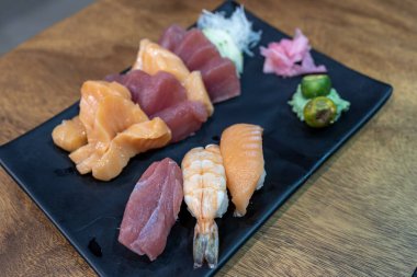 Restauranttaki siyah tabakta popüler Japon yemeği suşisi.