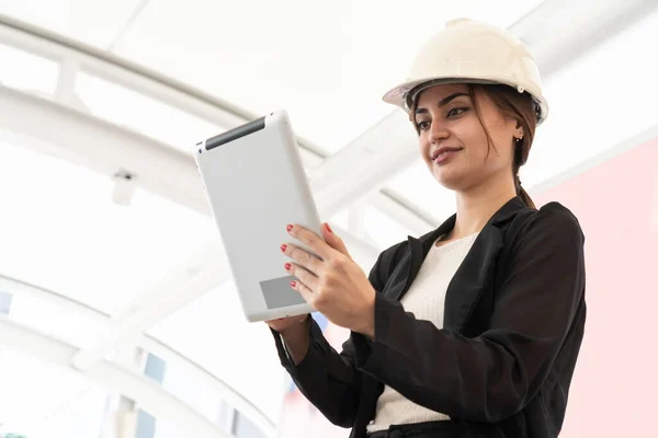ハード帽子をかぶっているエンジニア労働者はタブレットコンピュータを使用する 成功しました タブレットチェックリストを扱うビジネスマン 仕事中の女性 幸せな職場 — ストック写真