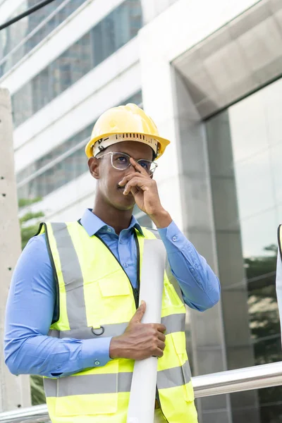 Engineer Worker Wearing Hard Hat. Happy Successful. Portrait of young African man wearing yellow hard hat helmet. Worker Wearing Safety Vest and Hard Hat