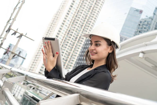 Engineer Worker Wearing Hard Hat Uses Tablet Computer. Happy Successful. Businesswomen working with tablet checklist. woman working.