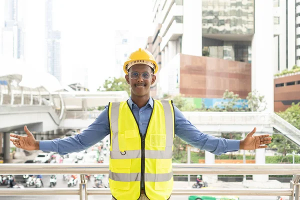 Engineer Worker Wearing Hard Hat. Happy Successful. Portrait of young African man wearing yellow hard hat helmet. Worker Wearing Safety Vest and Hard Hat