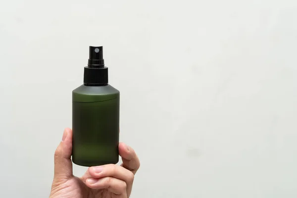 Green cosmetic bottle with label isolated on white background. Close up aroma spray bottle. Concept of organic cruelty free. Natural organic spa cosmetics concept.