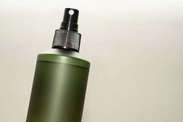 Green cosmetic bottle with label isolated on white background. Close up aroma spray bottle. Concept of organic cruelty free. Natural organic spa cosmetics concept.