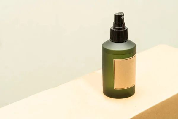 Green cosmetic bottle with label isolated on white background. Close up aroma spray bottle. Concept of organic cruelty free. Natural organic spa cosmetics concept.