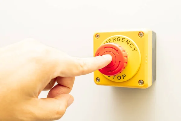 Stop Button and the Hand of Worker About to Press it. emergency stop button. Big Red emergency button or stop button for manual pressing.