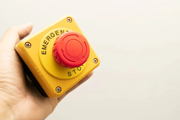 Stop Button and the Hand of Worker About to Press it. emergency stop button. Big Red emergency button or stop button for manual pressing.