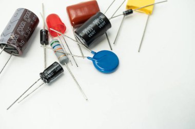 Çeşitli elektronik bileşenlerden oluşan bir grup: diyot, kapasitörler, direnişçiler, LED 'ler. beyaz arkaplanda izole