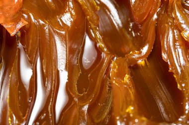 Turuncu renkli endüstriyel yağları kapatın. Metal sürtünmeyi yumuşatmak için kullanılan zengin ve kalın endüstriyel yağ dokusu. Kayganlaştırıcı yağ. Makine için sarı lityum yağı yakın çekim