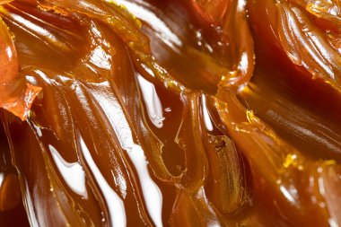 Turuncu renkli endüstriyel yağları kapatın. Metal sürtünmeyi yumuşatmak için kullanılan zengin ve kalın endüstriyel yağ dokusu. Kayganlaştırıcı yağ. Makine için sarı lityum yağı yakın çekim